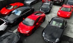 Close-up of red and black exotic cars in lot.